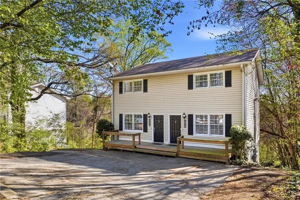 a front view of a house with a tree