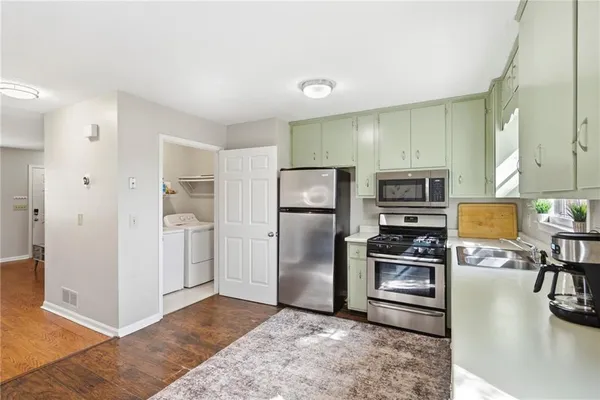a kitchen with stainless steel appliances a refrigerator and a stove top oven