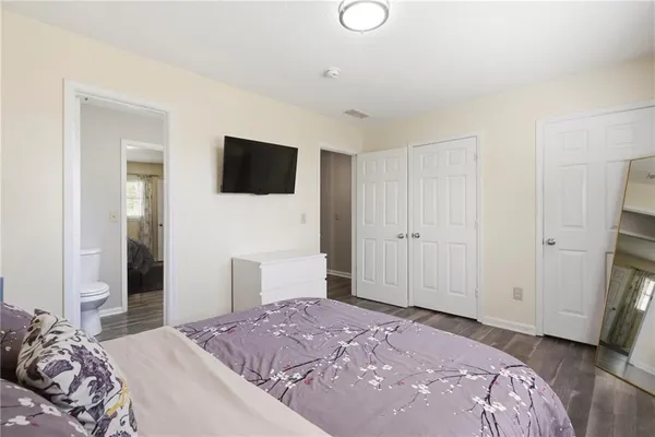 a bedroom with a bed and a flat screen tv