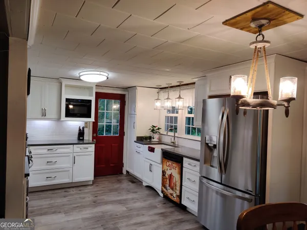 a kitchen with stainless steel appliances a refrigerator a sink a stove and cabinets