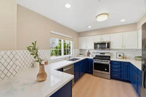 a kitchen with stainless steel appliances granite countertop a sink stove and microwave