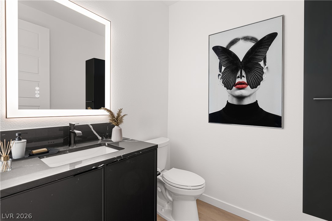 11027 Socrates Ridge Street Las Vegas, NV 89141 - Photo 3 of 20 A well-appointed lavatory featuring a sleek vanity and a contemporary illuminated mirror.