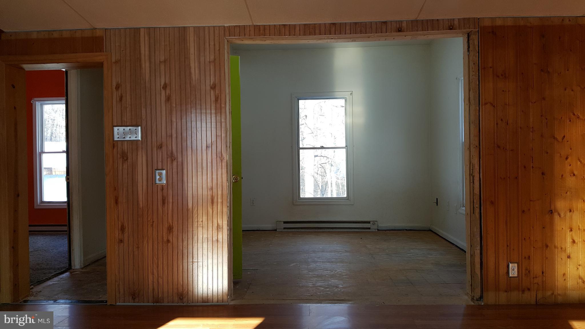 24581 Hells Delight Road Smithsburg, MD 21783 - Photo 6 of 22 an empty room with wooden floor and windows