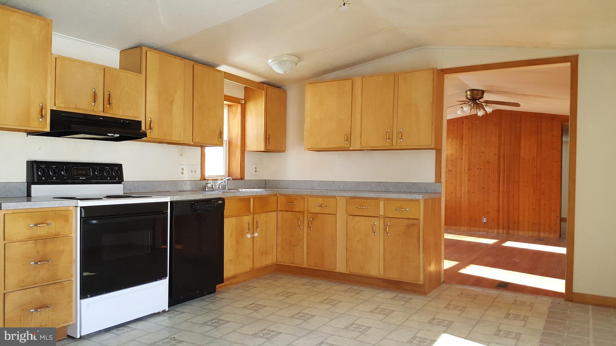 24581 Hells Delight Road Smithsburg, MD 21783 - Photo 7 of 22 a kitchen with granite countertop a refrigerator a stove top oven and cabinets