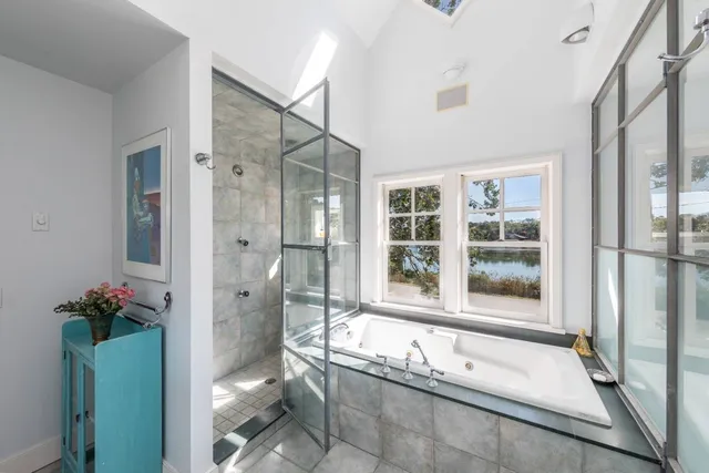 a bathroom with a granite countertop tub shower and mirror