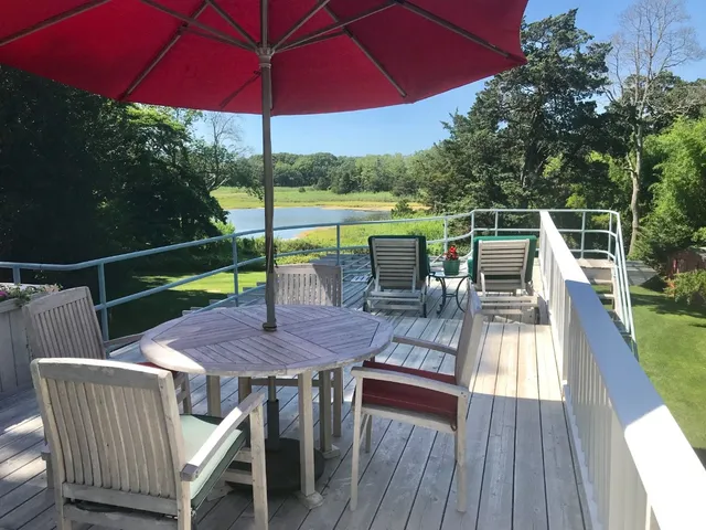 a view of deck with table and chairs under an umbrella