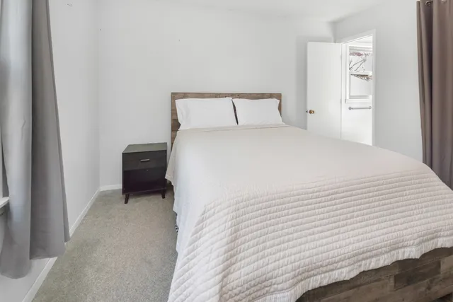 a bedroom with a bed and a painting on the wall