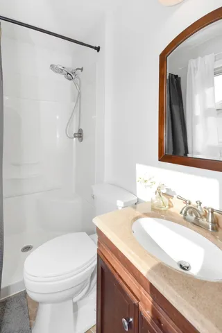 a bathroom with a granite countertop sink toilet and a mirror