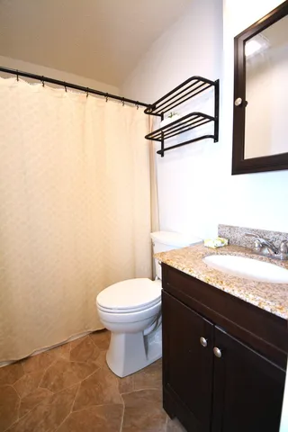a bedroom with a bed and a flat tv screen on dresser