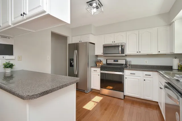 a kitchen with granite countertop white cabinets and white appliances