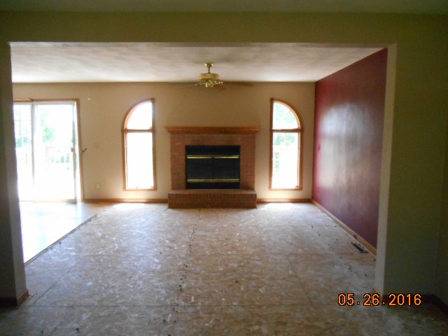 938 Lake Summerset Road Davis, IL 61019 - Photo 4 of 25 an empty room with a fireplace and windows