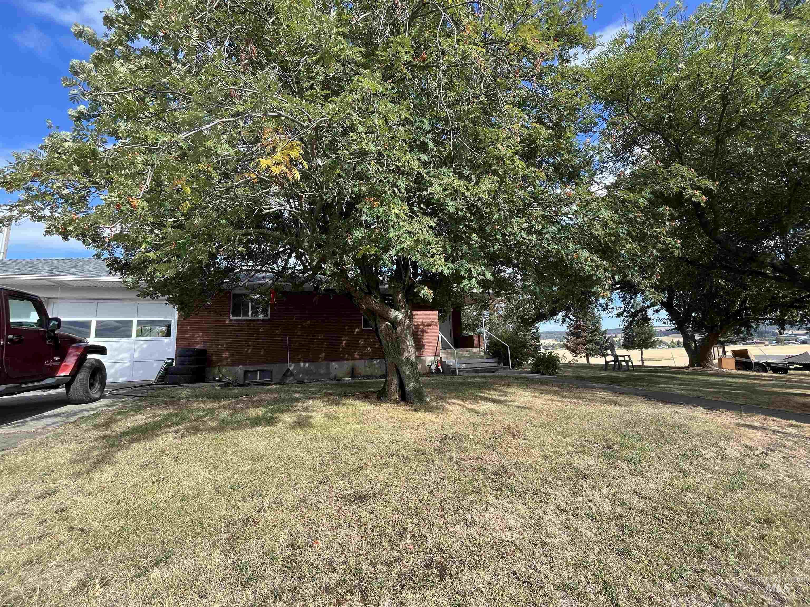 1048 Reynolds Road Princeton, ID 83857 - Photo 31 of 41 View of green lawn with a garage and covered porch
