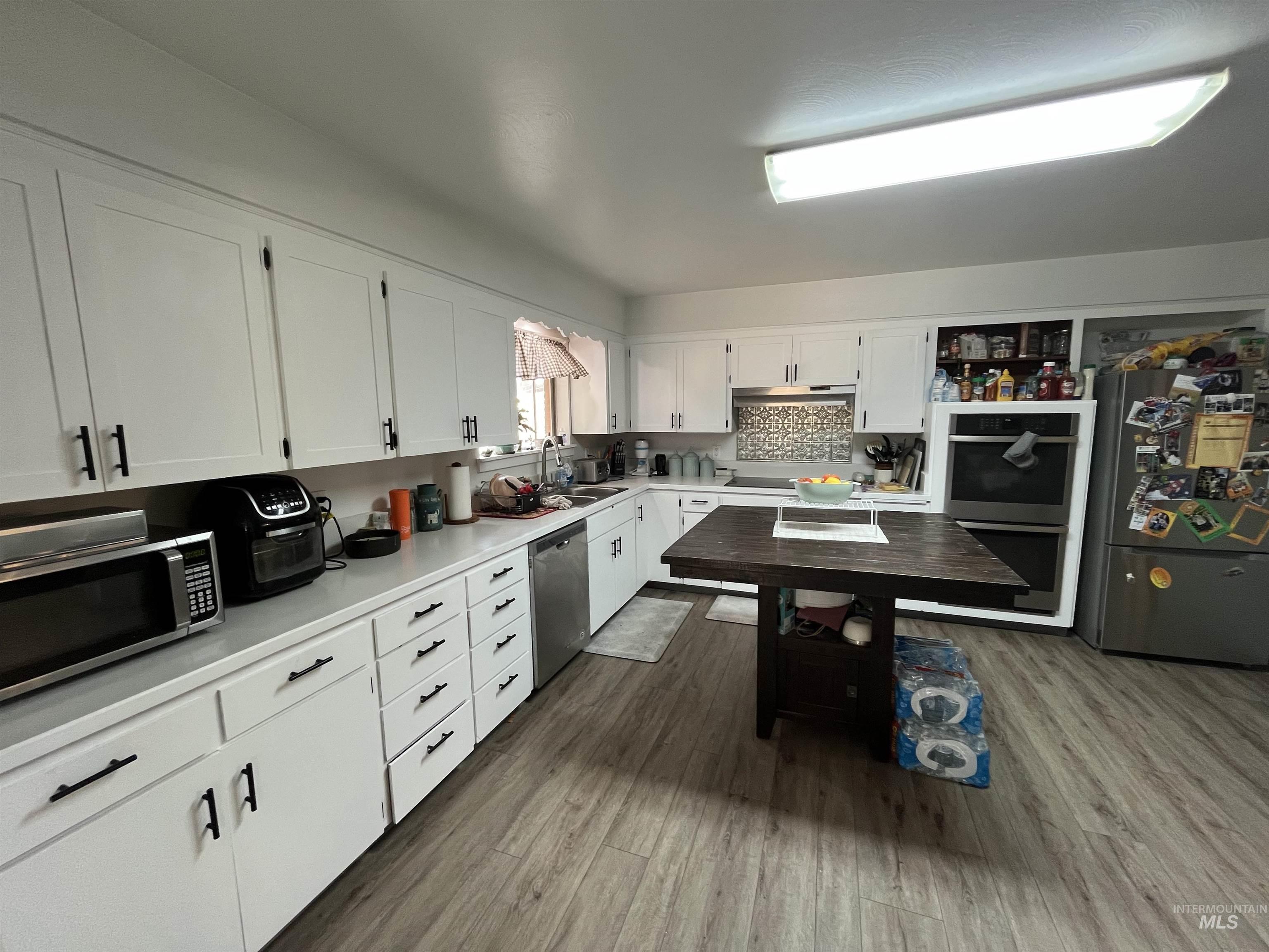 1048 Reynolds Road Princeton, ID 83857 - Photo 7 of 41 Kitchen featuring light countertops, white cabinetry, appliances with stainless steel finishes.