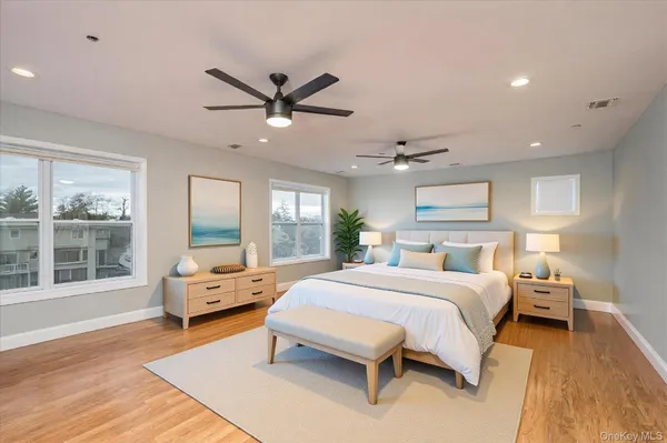 a bedroom with a large bed and windows