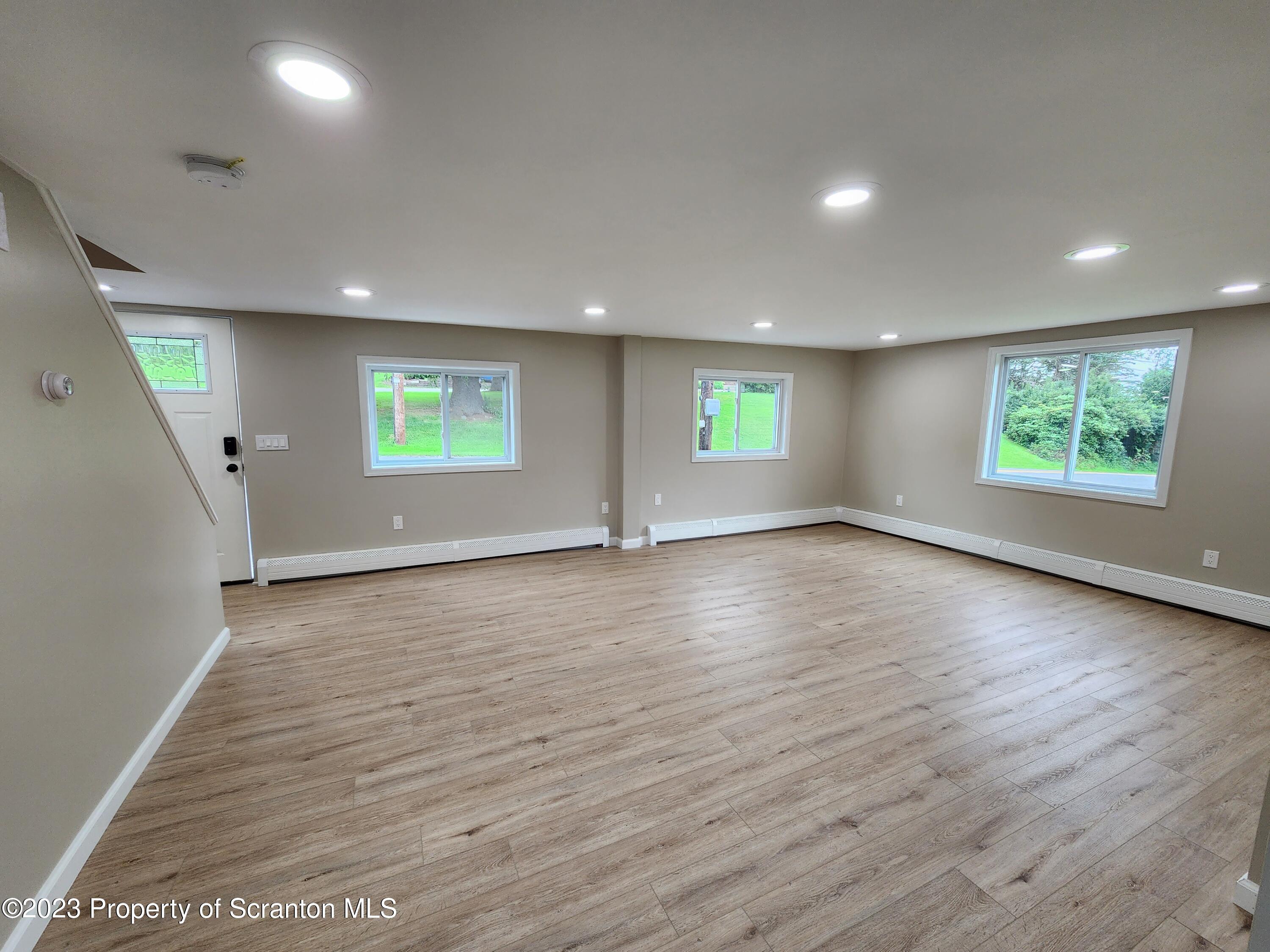 257 Maple Drive Dalton, PA 18414 - Photo 6 of 31 an empty room with wooden floor and windows