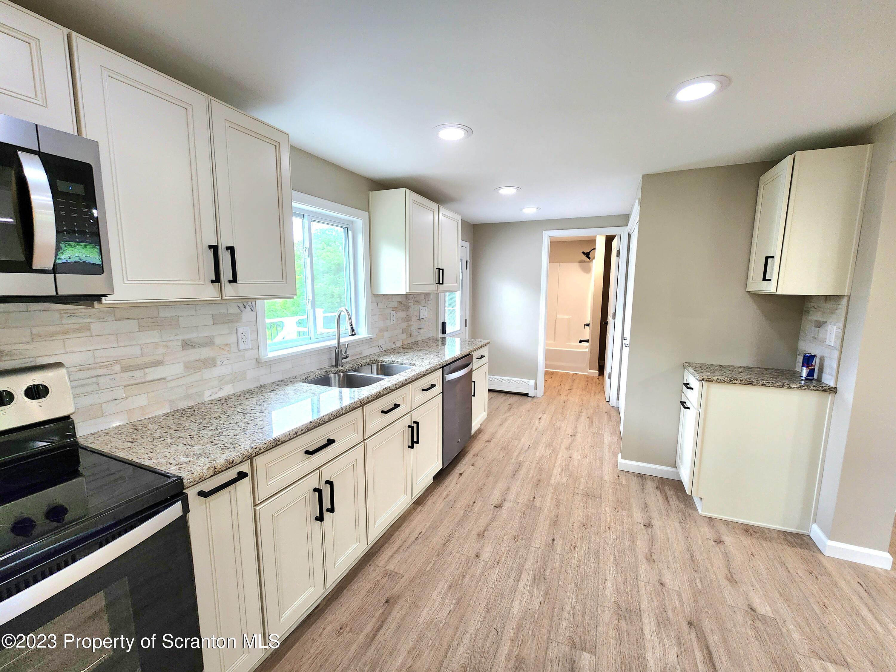 257 Maple Drive Dalton, PA 18414 - Photo 8 of 31 a kitchen with sink a stove and wooden floor