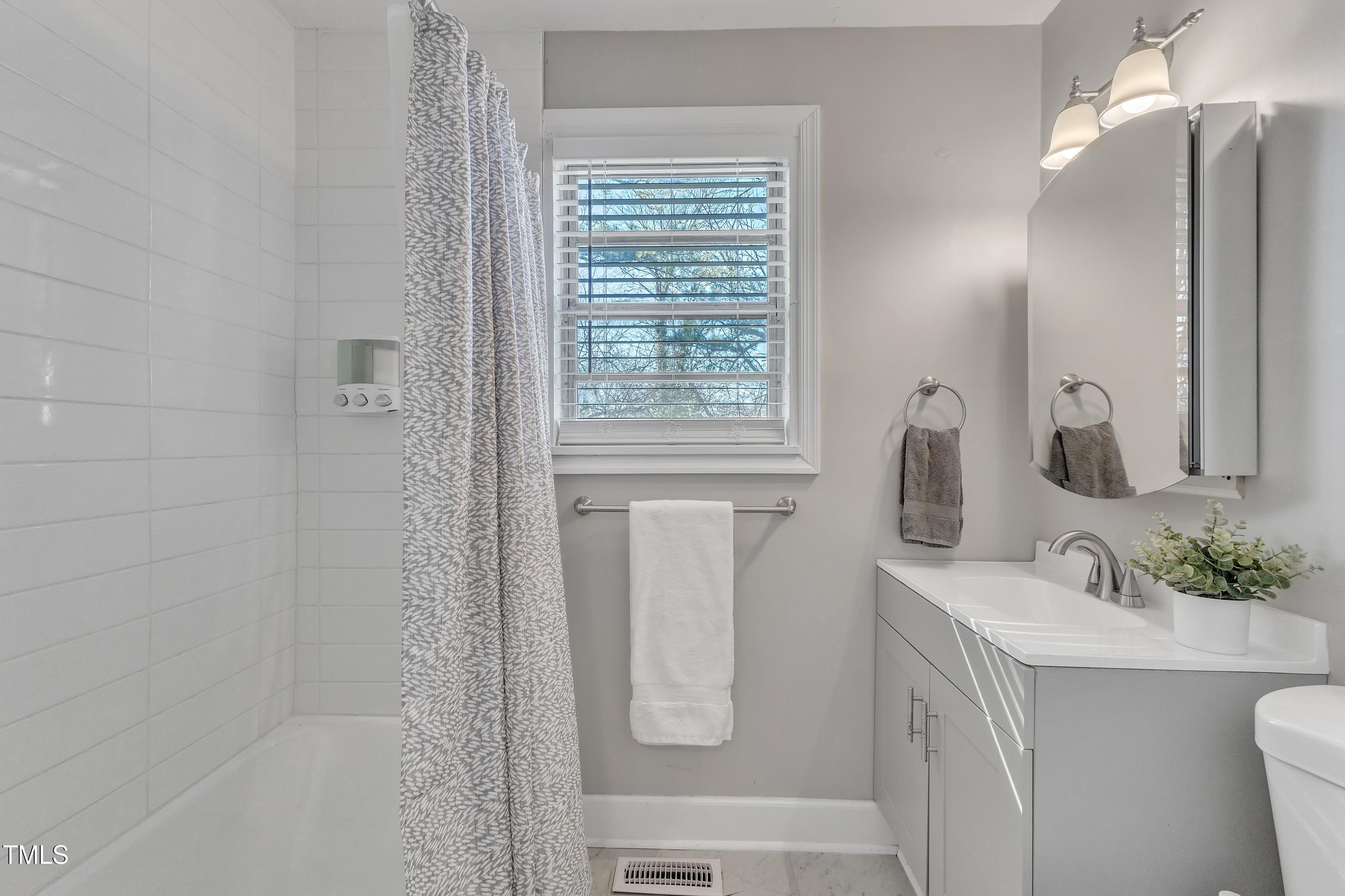 602 Quarry Street Raleigh, NC 27601 - Photo 16 of 49 a bathroom with a shower sink and mirror