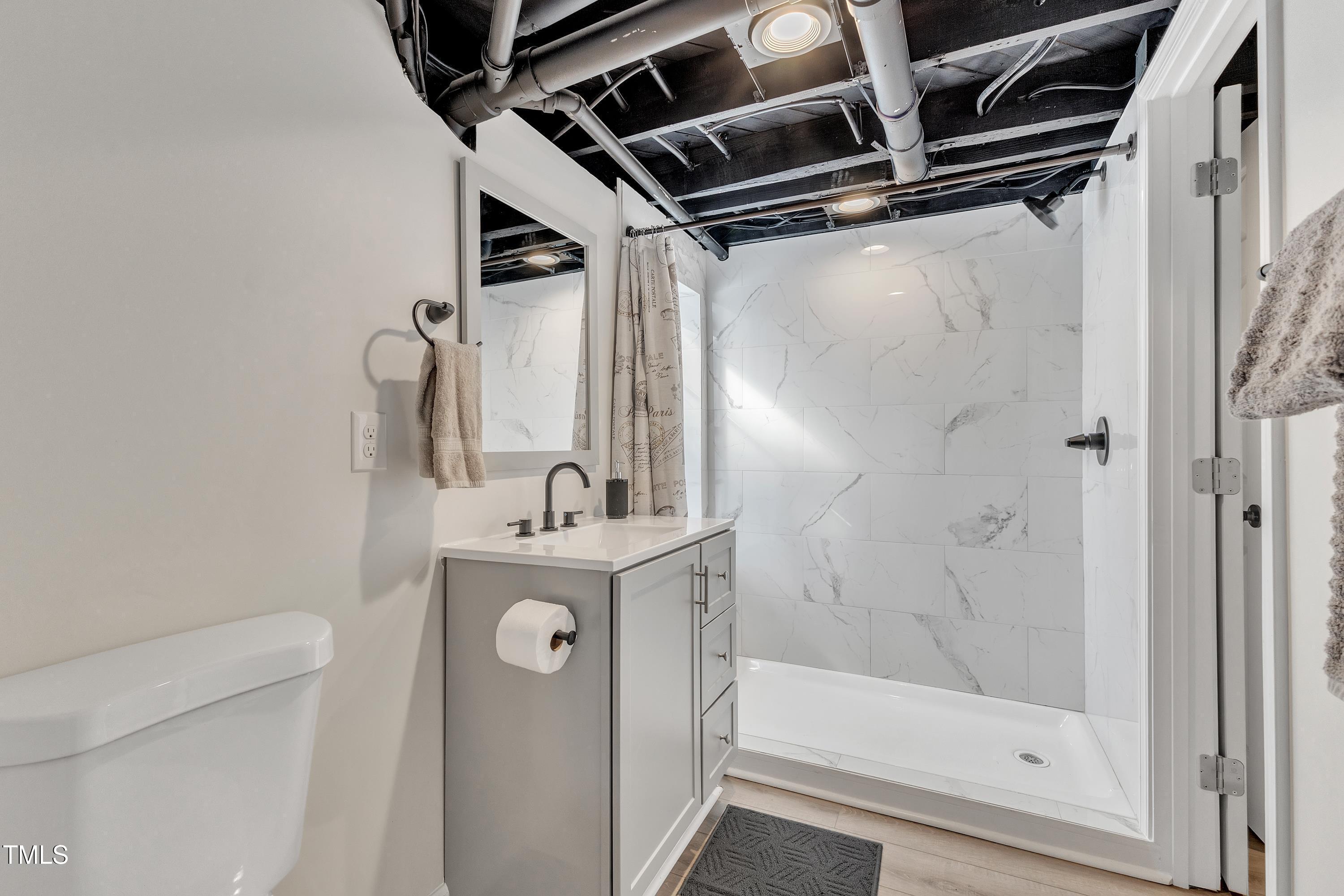 602 Quarry Street Raleigh, NC 27601 - Photo 33 of 49 a bathroom with a shower a mirror and a sink