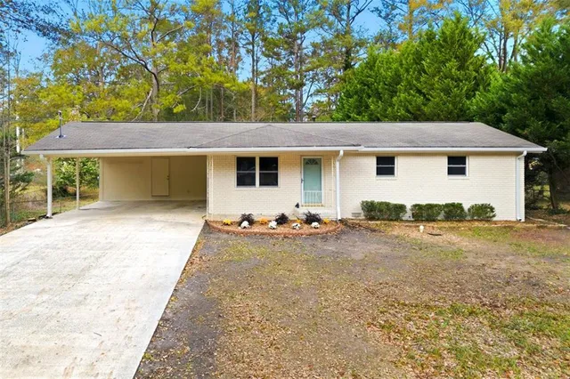 a view of a house with backyard and trees