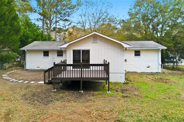 a view of a house with a yard and large tree