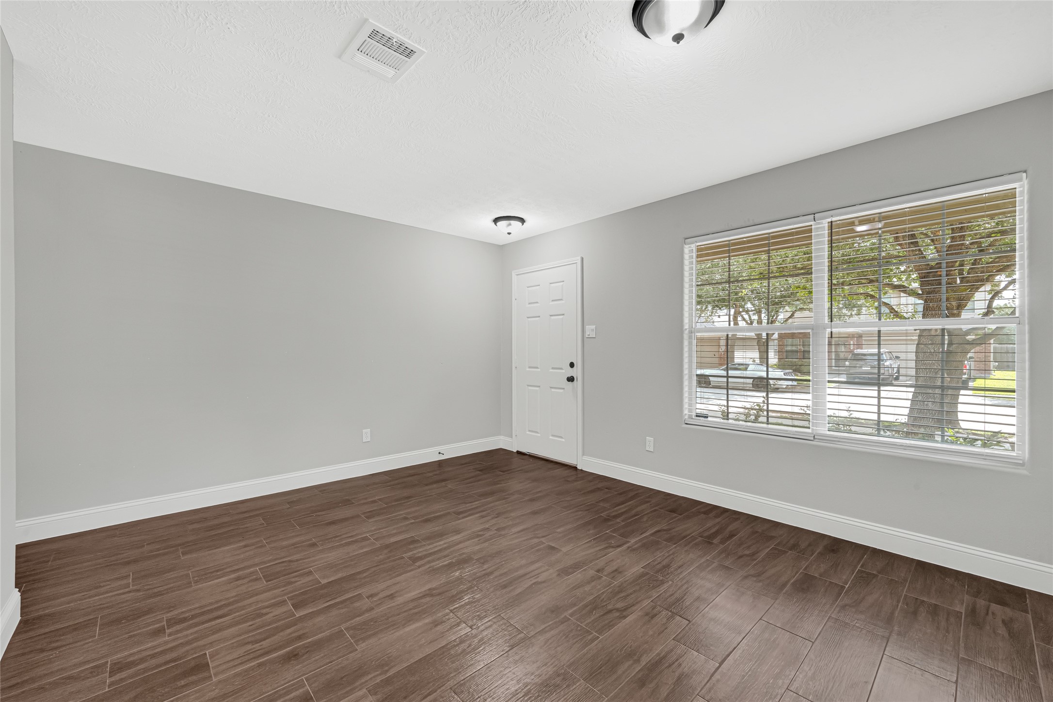 10406 Bentondale Lane Houston, TX 77075 - Photo 4 of 27 a view of an empty room with wooden floor and windows