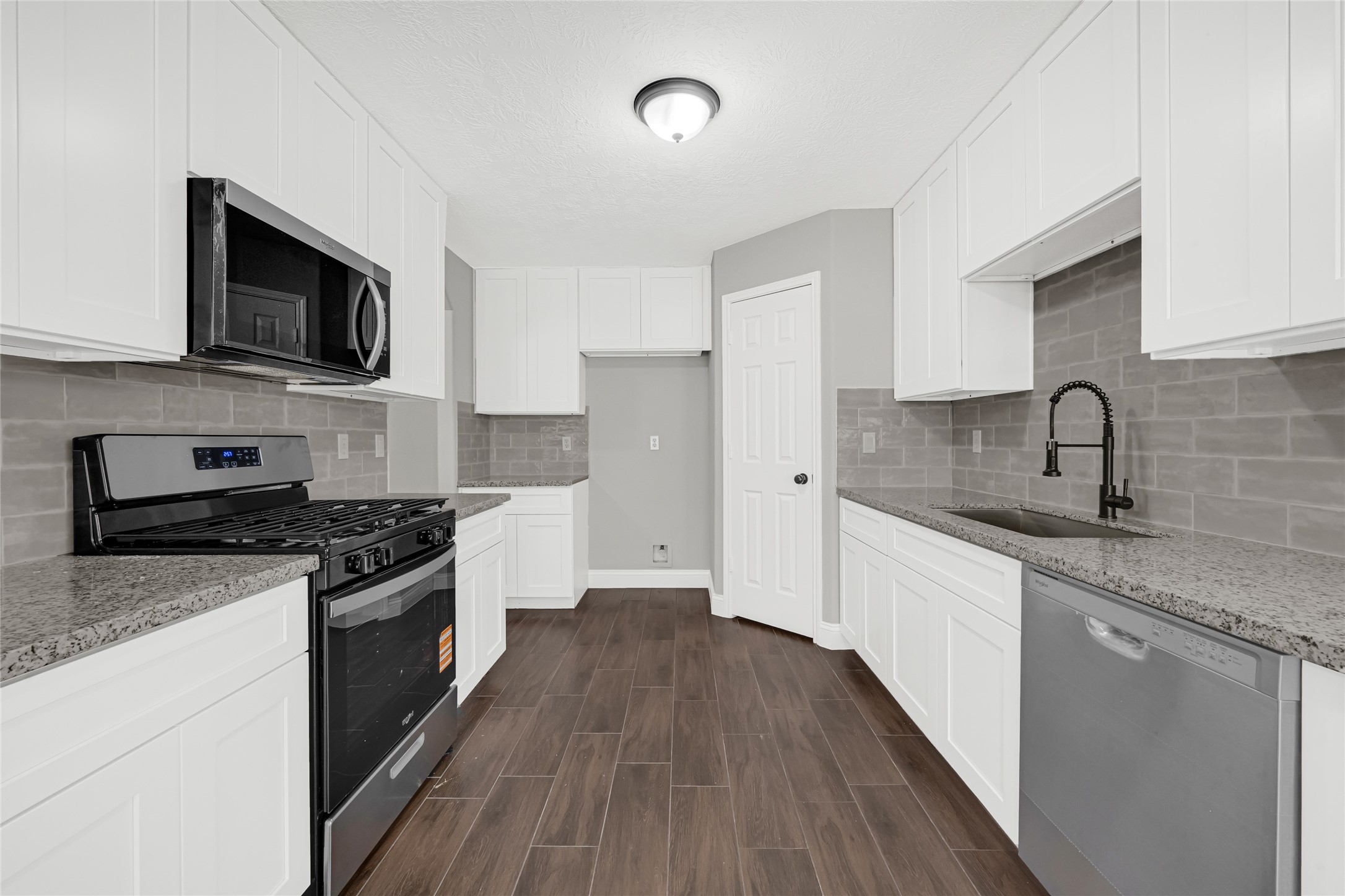 10406 Bentondale Lane Houston, TX 77075 - Photo 5 of 27 a kitchen with stainless steel appliances granite countertop a stove top oven a sink dishwasher and a microwave oven with wooden floor