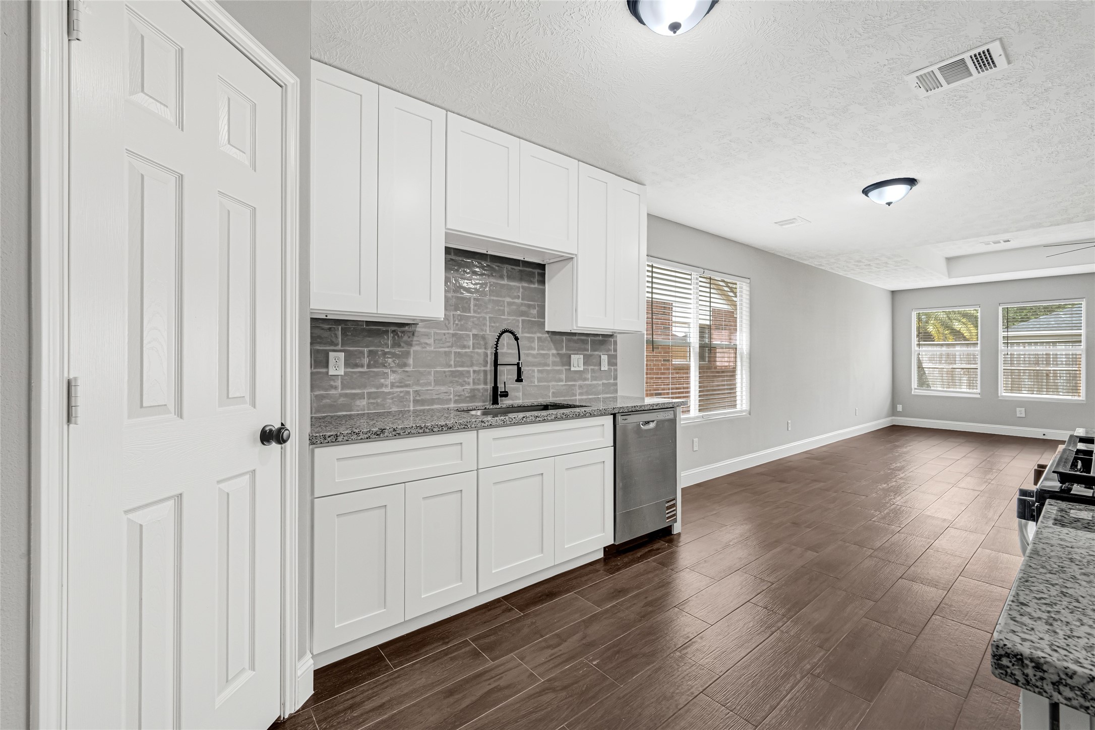 10406 Bentondale Lane Houston, TX 77075 - Photo 6 of 27 a kitchen with stainless steel appliances granite countertop a stove a sink and white cabinets with wooden floor