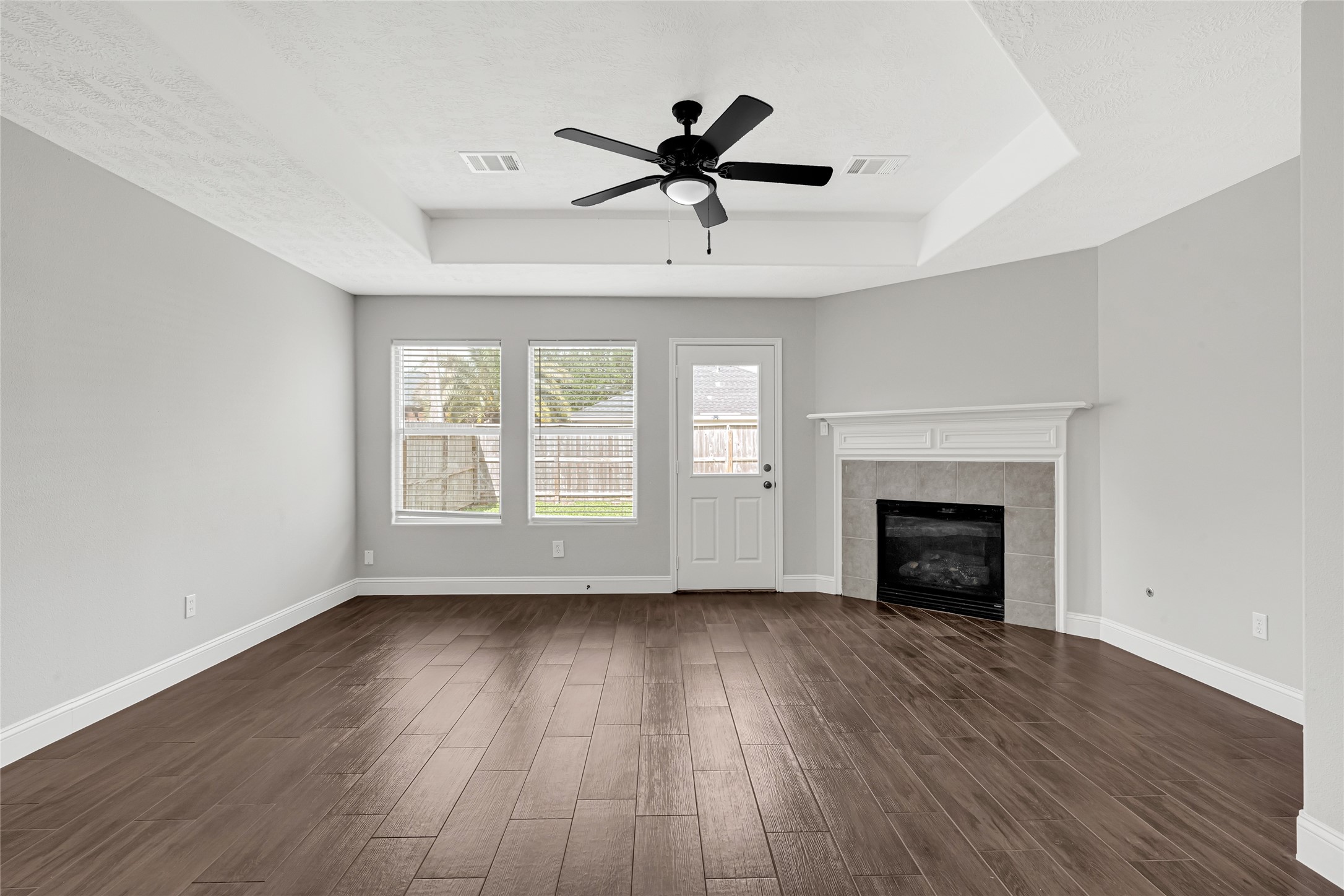 10406 Bentondale Lane Houston, TX 77075 - Photo 8 of 27 an empty room with wooden floor a ceiling fan and windows