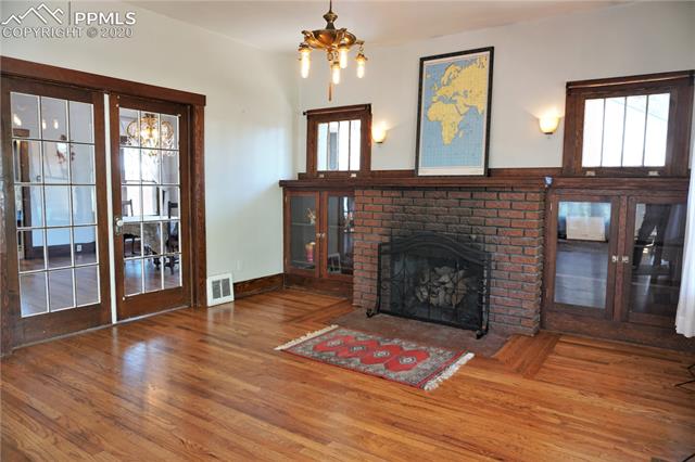 320 West Cheyenne Road Colorado Springs, CO 80906 - Photo 6 of 18 Classic brick fireplace with oak-trimmed hearth, hardwood mantle, tilt-in windows, glass front built-in bookcases, sconce lighting, French doors, and an irreplaceable feel of warmth and home.