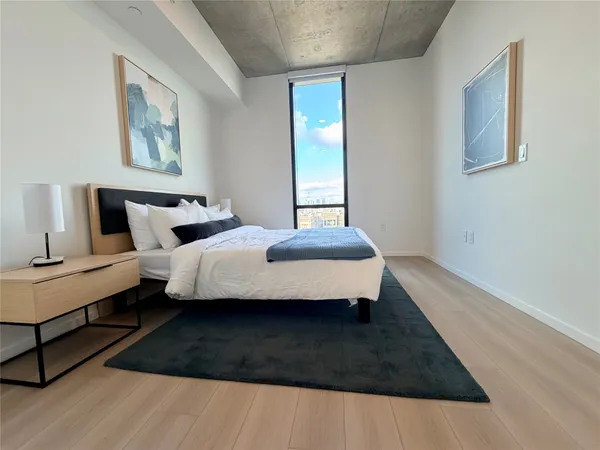 a bedroom with a bed wooden floor and lamp