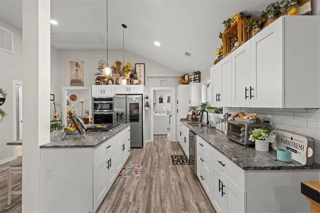 a kitchen with stainless steel appliances granite countertop a sink stove and refrigerator