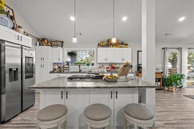 a kitchen with a table chairs sink and refrigerator