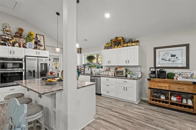 a kitchen with stainless steel appliances a stove a sink and a refrigerator