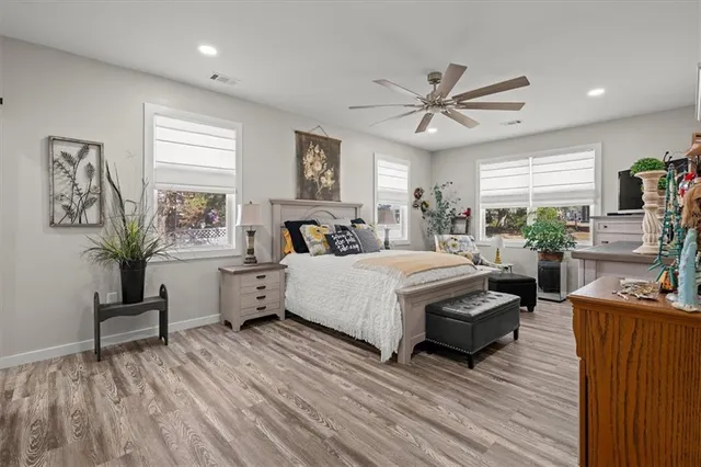 a large bedroom with a bed and wooden floor