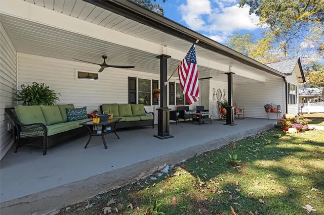 a backyard of a house with sofas table and chairs