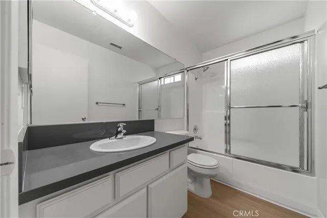 a bathroom with a granite countertop sink toilet a mirror and shower