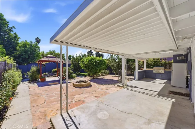 a view of a patio with a table and chairs under an umbrella
