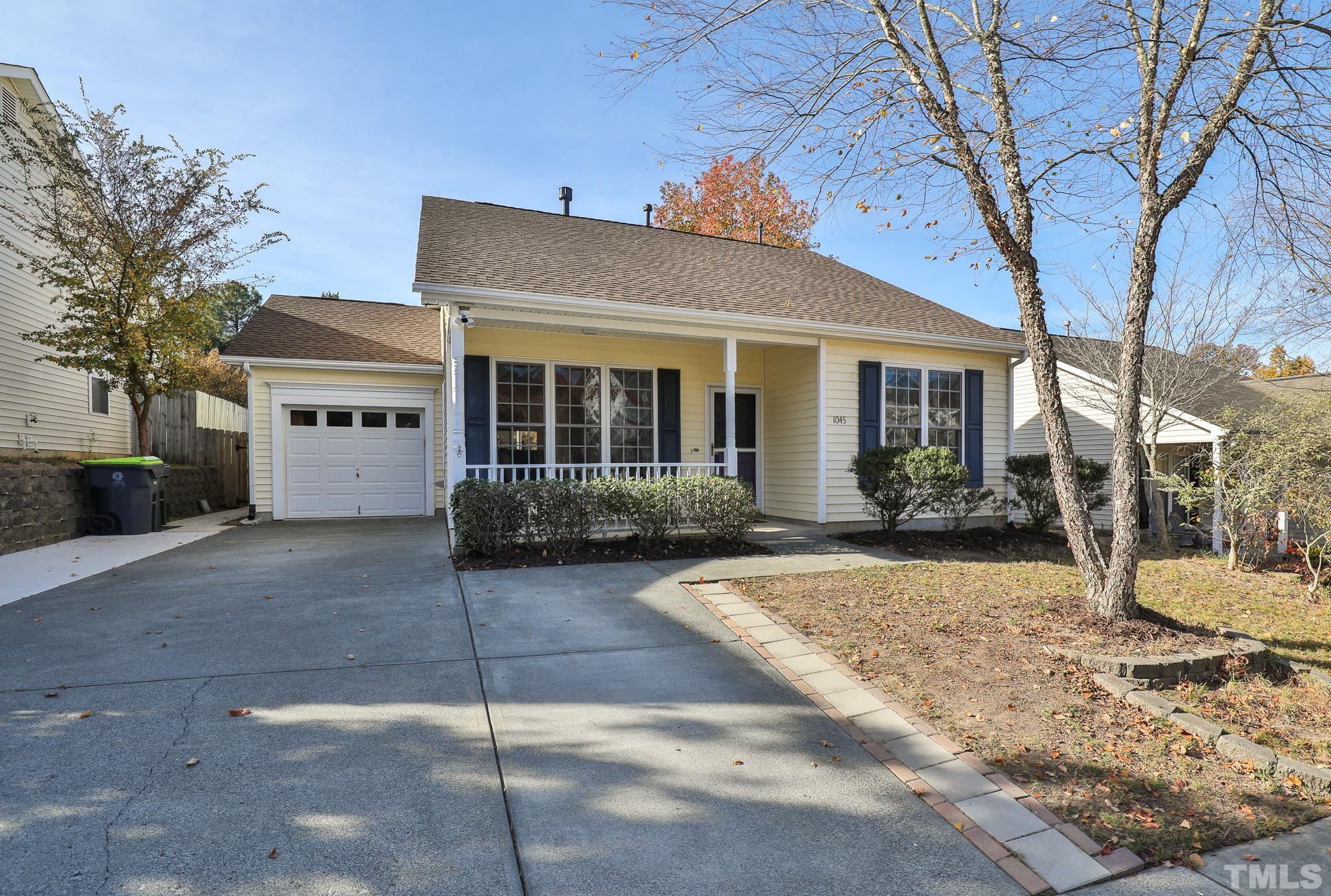 a view of a white house with a tree in front of it