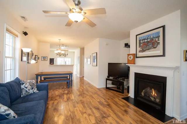 a living room with furniture a flat screen tv and a table