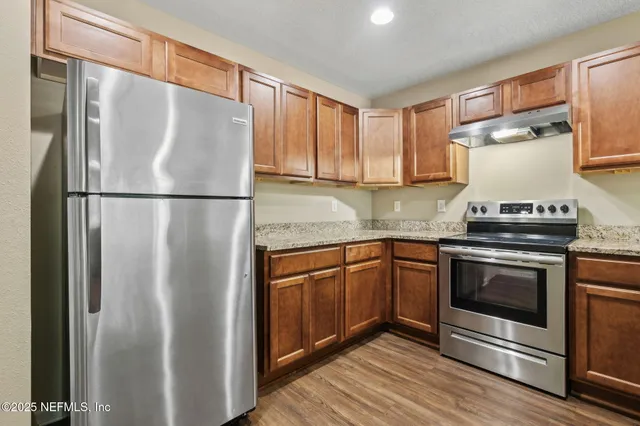 a kitchen with stainless steel appliances a refrigerator sink and cabinets