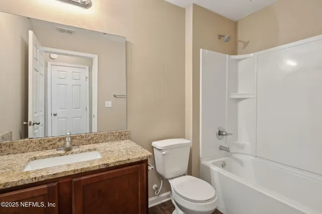 a view of an empty room with closet and a window