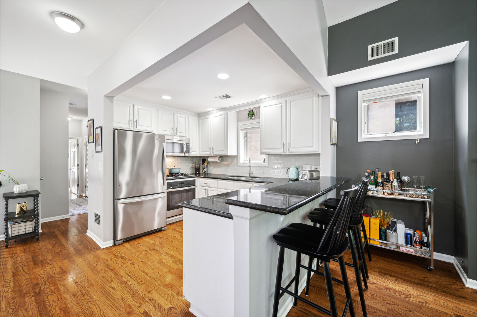 3223 North Seminary Avenue, Unit 3 Chicago, IL 60657 - Photo 7 of 17 a kitchen with granite countertop a refrigerator stove microwave and cabinets