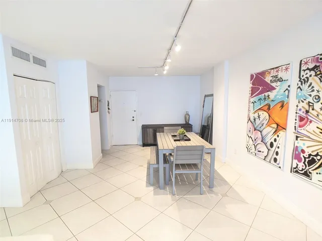 a kitchen with stainless steel appliances kitchen island granite countertop a refrigerator and a cabinets