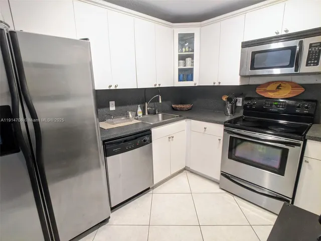 a kitchen with stainless steel appliances granite countertop a refrigerator stove and sink