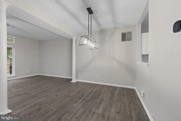 a view of empty room with wooden floor and ceiling fan