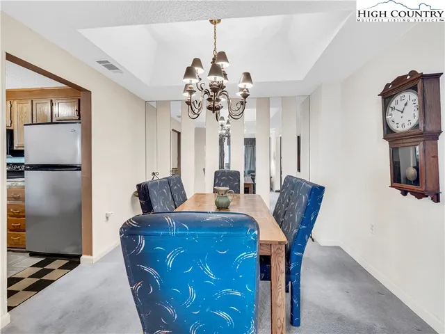a view of a dining room with furniture and a chandelier