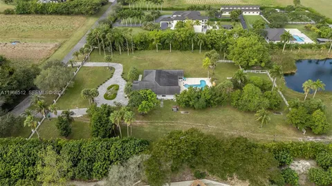an aerial view of residential houses with outdoor space and trees