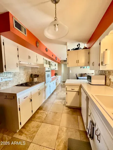a kitchen with a sink stove and white cabinets