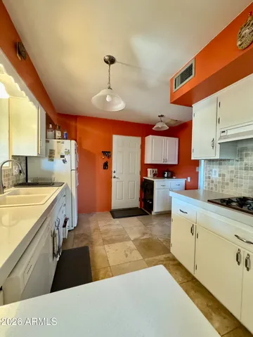 a large kitchen with stainless steel appliances granite countertop a sink and cabinets