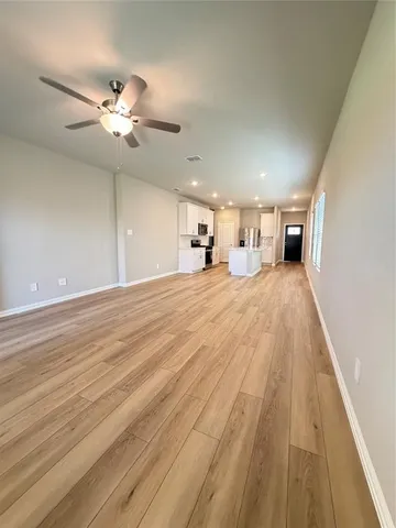 a view of a livingroom with a ceiling fan and wooden floor